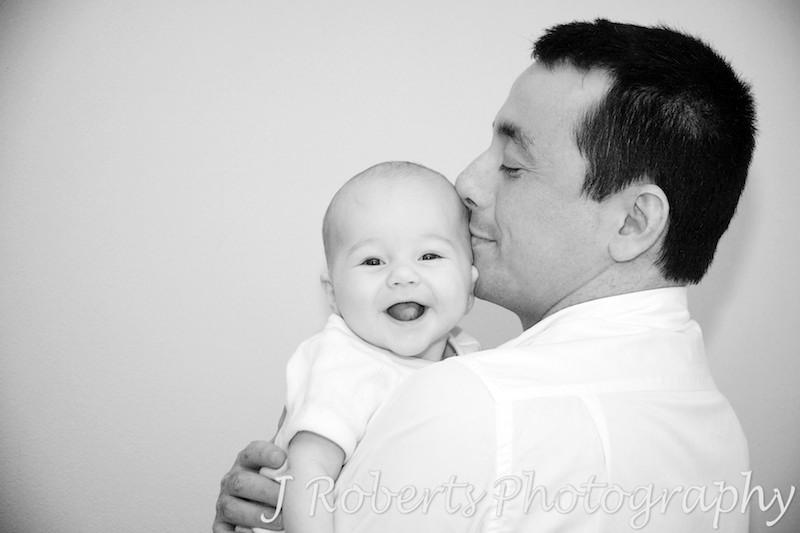 Baby laughing over Dad's shoulder - baby portrait photography sydney